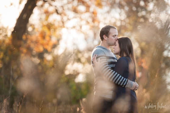 Photo of couple kissing in woods at fall engagement session
