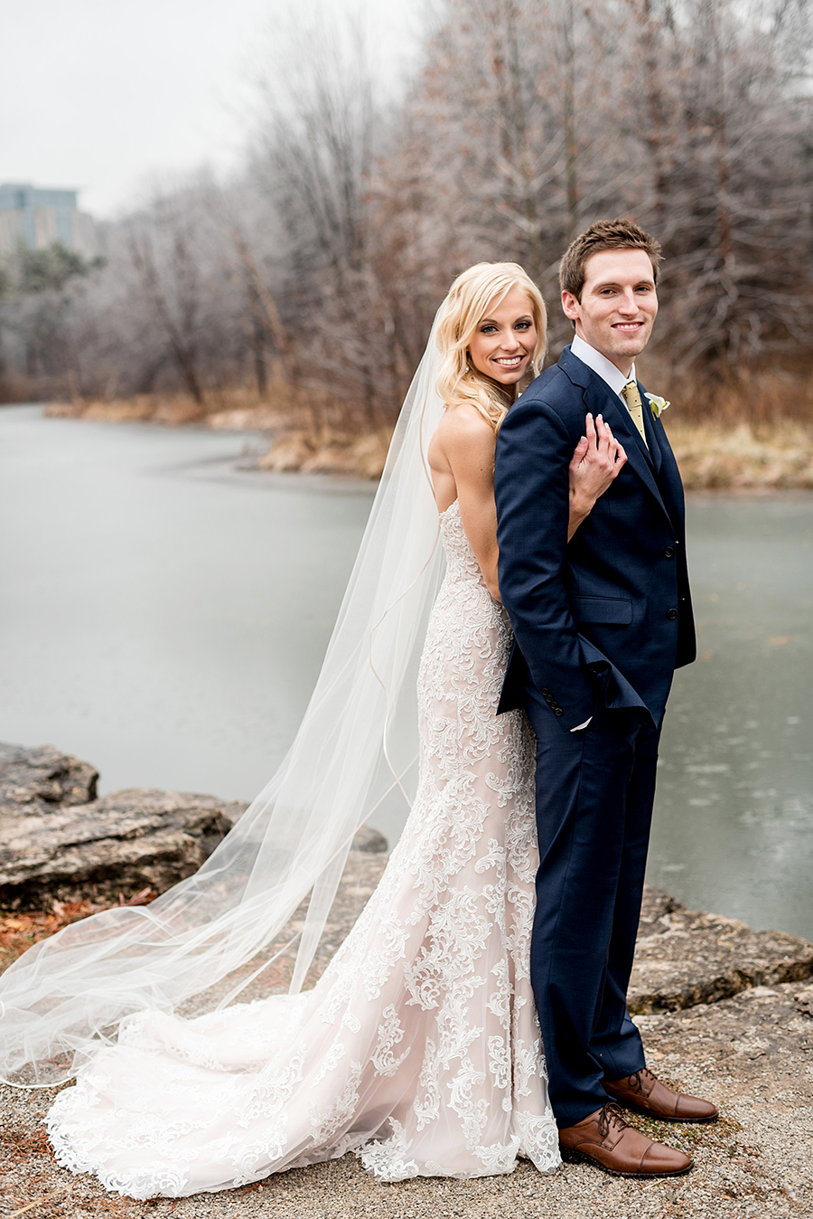 bride and groom near frozen river for a winter wedding at graham chapel by ashley fisher photography