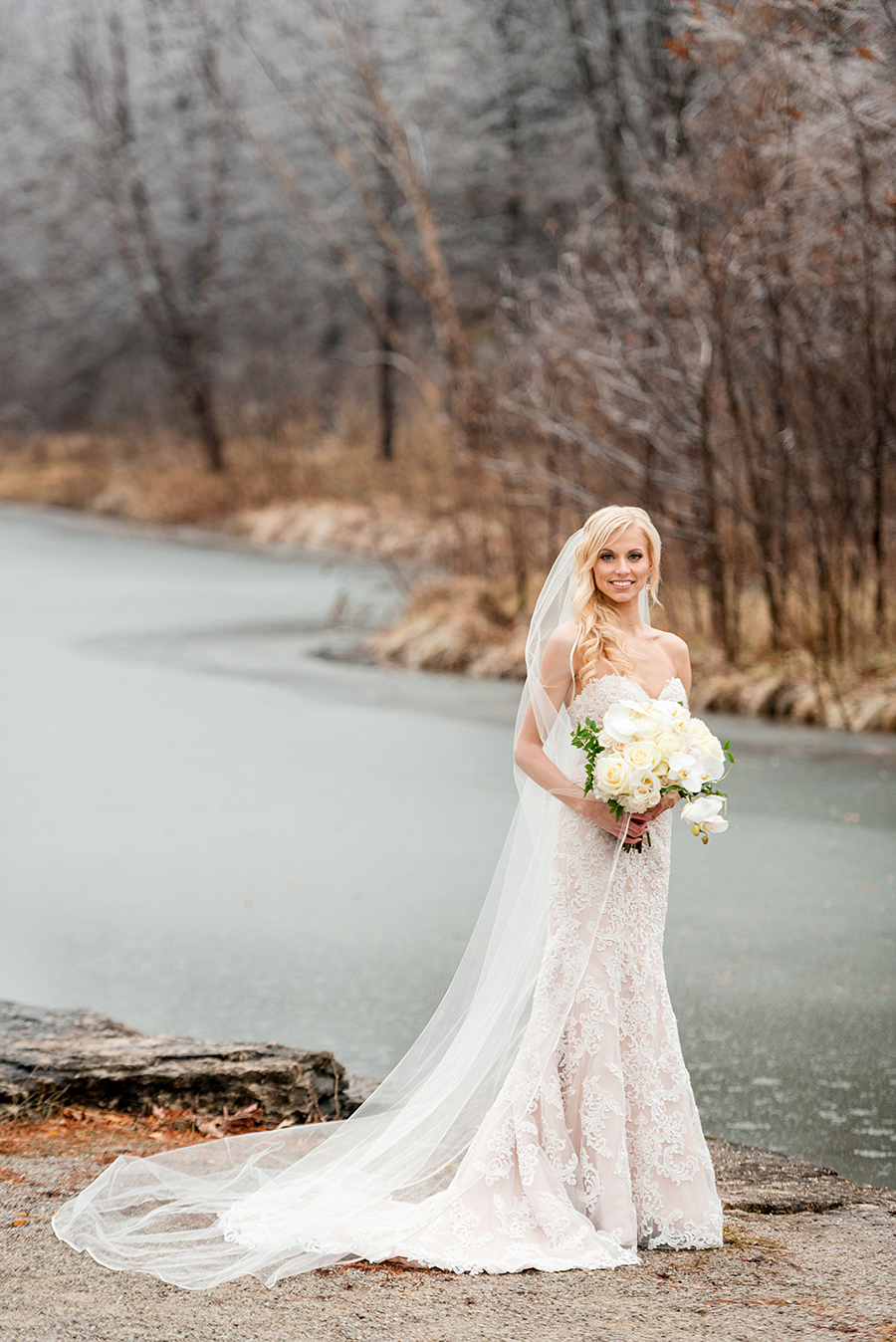 bridal portrait near frozen river for a winter wedding at graham chapel by ashley fisher photography