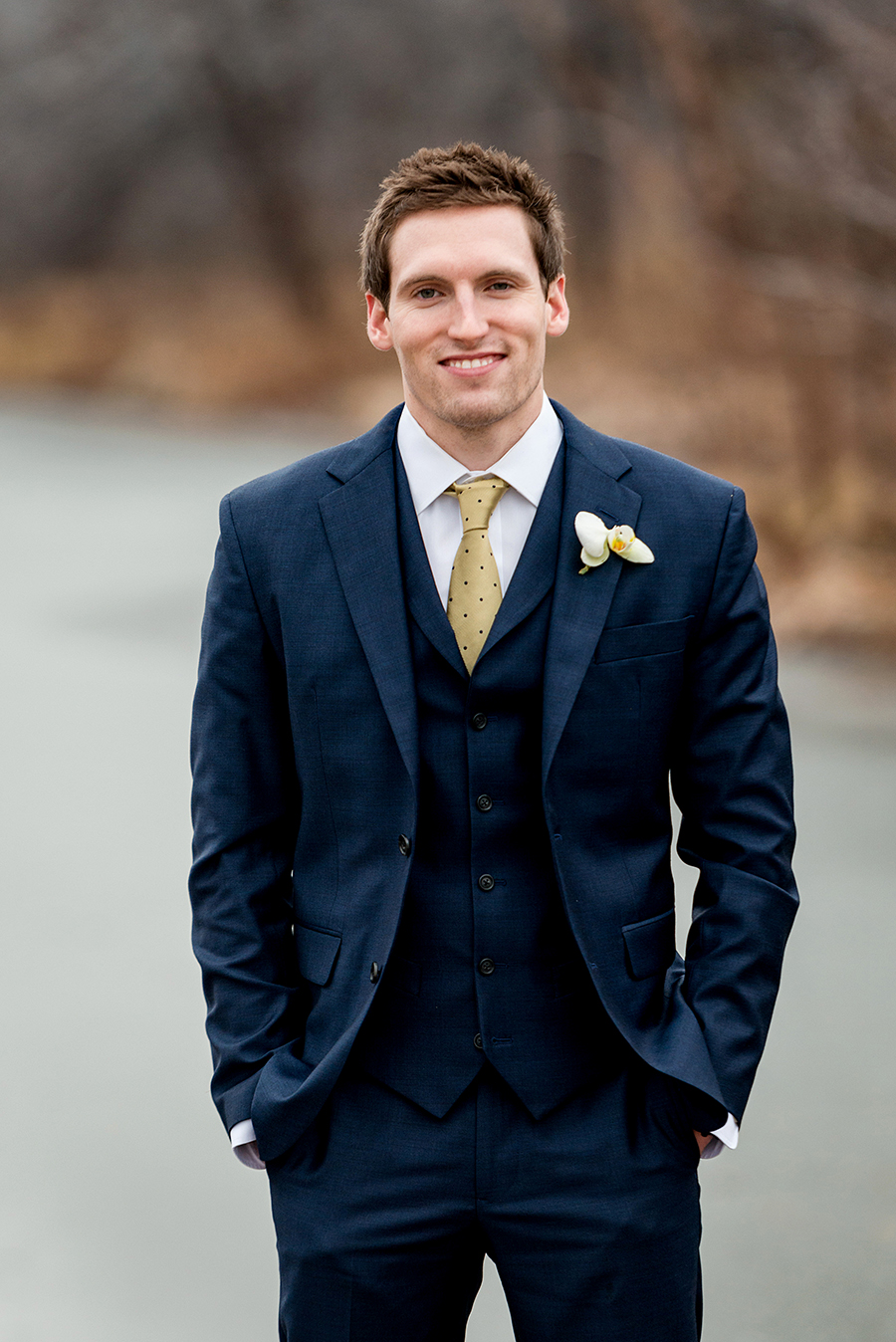 groom portrait near frozen river for a winter wedding at graham chapel by ashley fisher photography