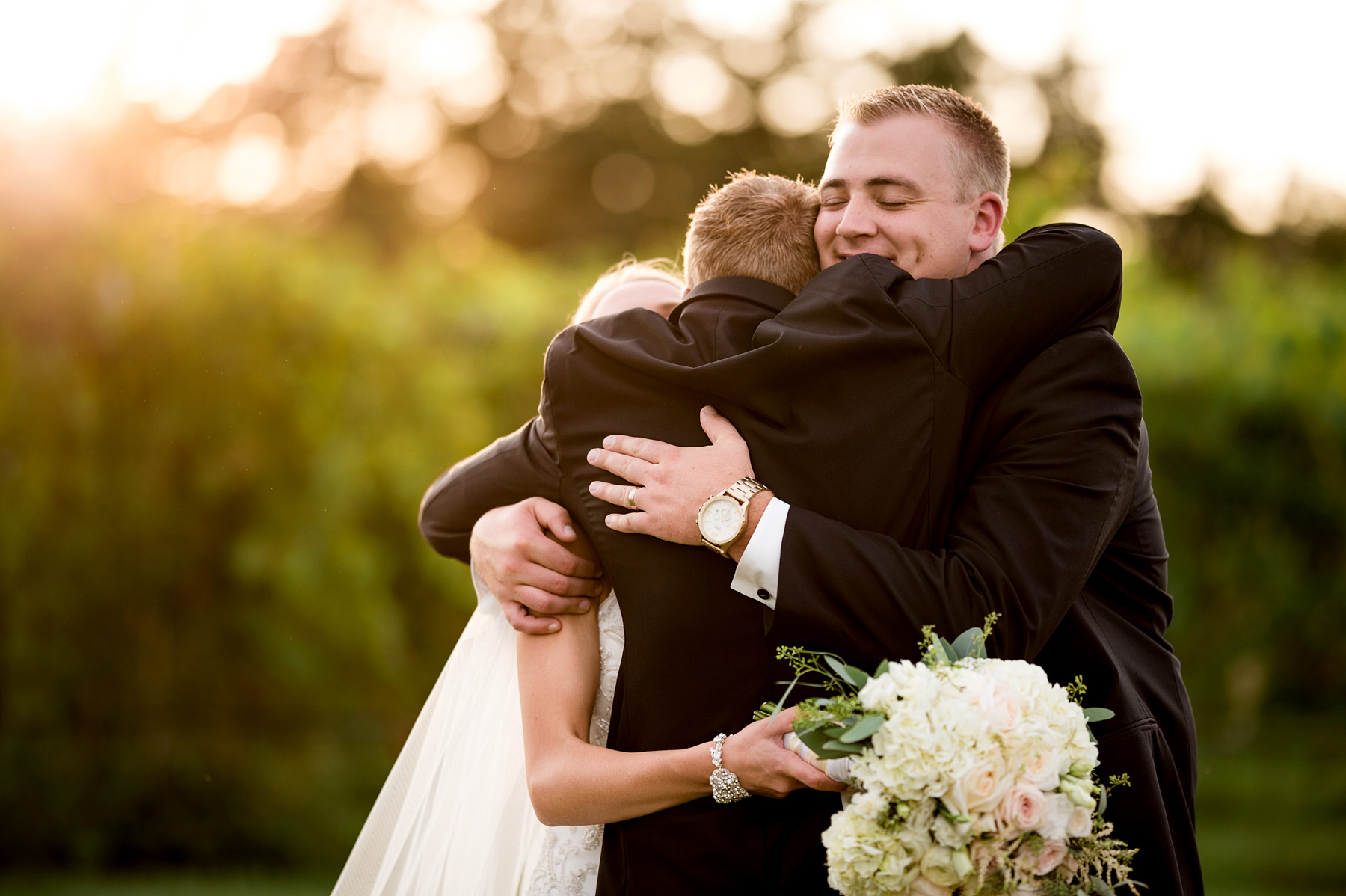 photo of bride and groom hugging best man by ashley fisher photography