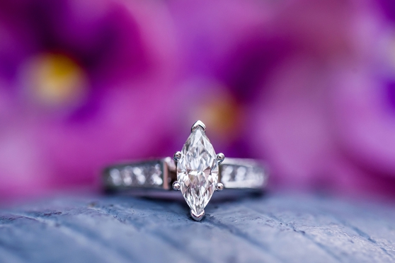Photo of beautiful marquette cut diamond engagement ring with purple background