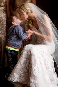 ringbearer giving the bride a kiss for a winter wedding at graham chapel by ashley fisher photography