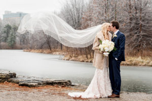 bride wearing vintage fur coat and veil toss for a winter wedding at graham chapel by ashley fisher photography