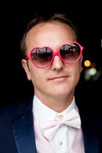 photo of groom wearing pink heart sunglasses by ashley fisher photography