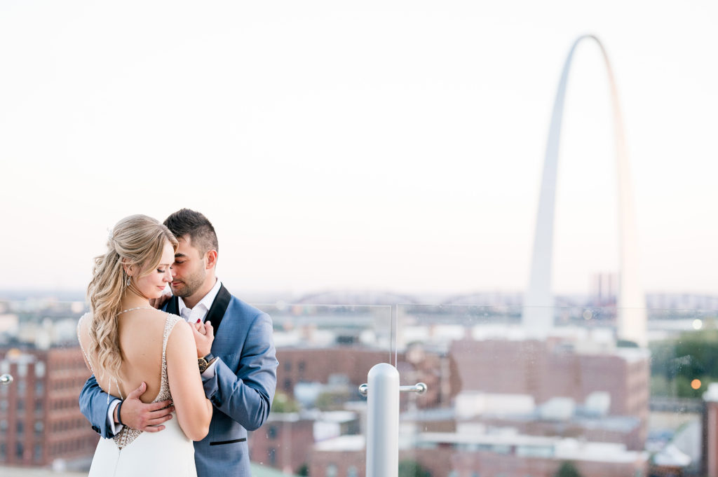 sunset portrait of bride and groom on the four seasons rooftop overlooking the st louis arch