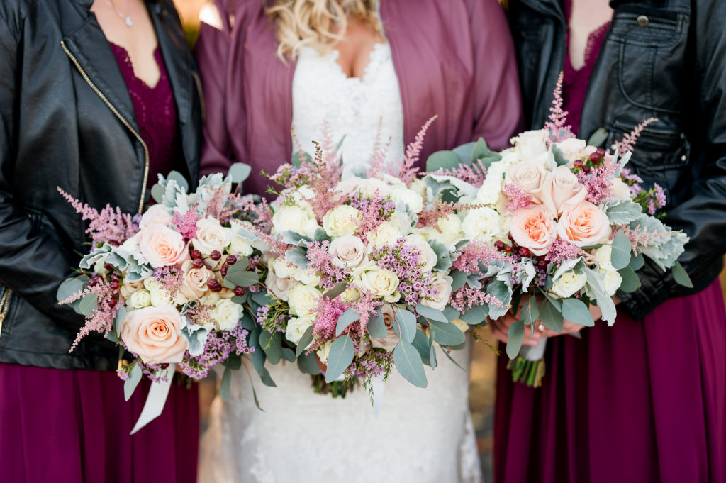 bride and bridesmaids in leather jackets with pretty bouquets