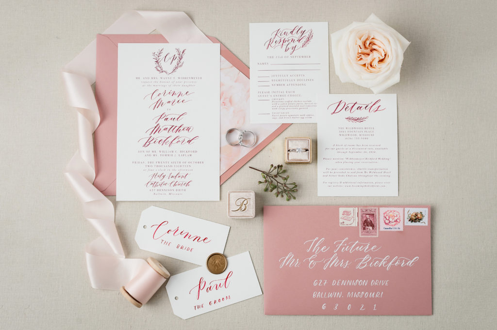 layflat of calligraphed wedding invitation suite styled on neutral linen styling board