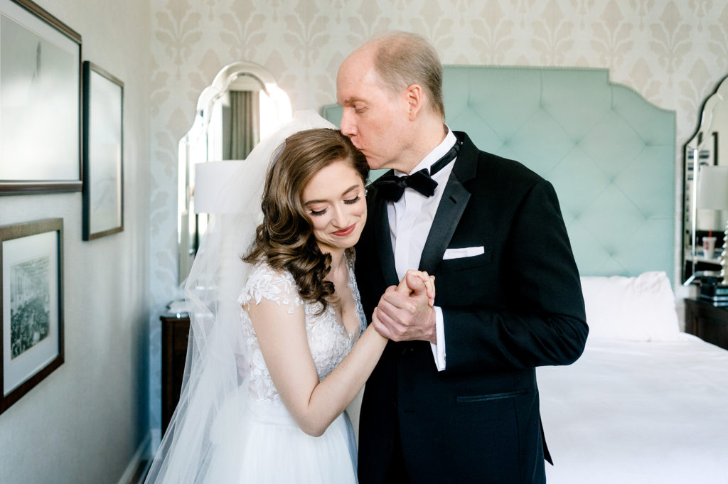 dad's first look with bride with a kiss on the forehead in suite at union station hotel