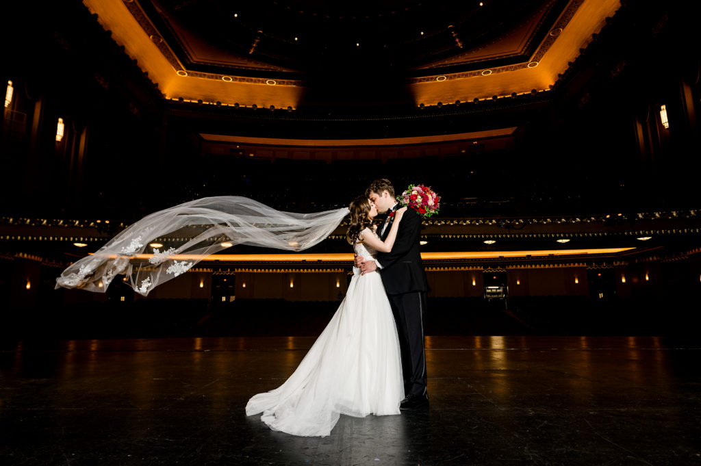 veil toss bride and groom kiss on stage of stifel theater wedding