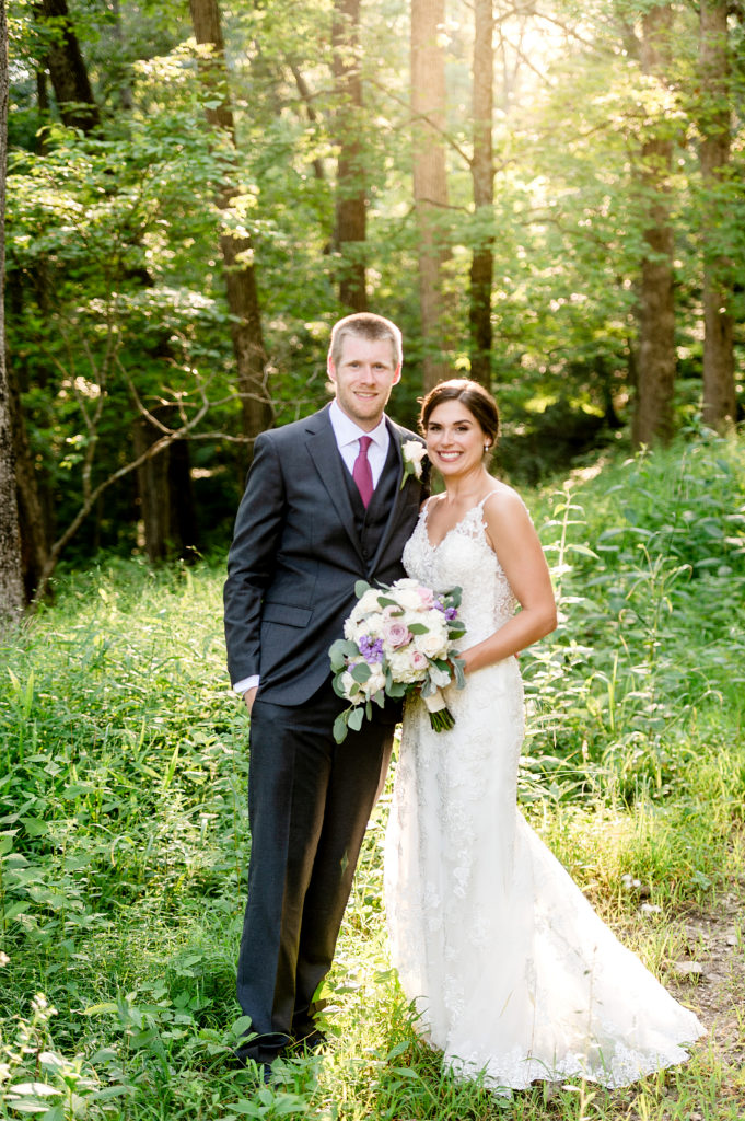 Bride and groom looking at the camera at sunset in the woods at Silver Oaks Chateau
